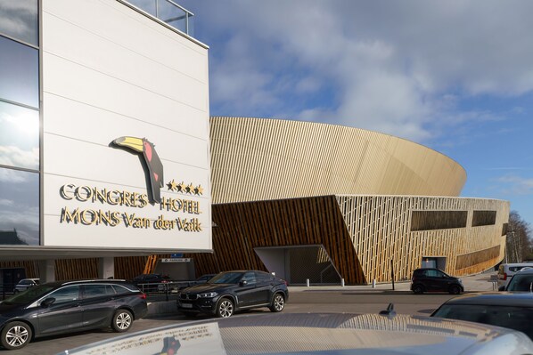 Un edificio moderno con fachada curva y un cartel grande que dice "CONGRES HOF MONS VAN der Valk".
