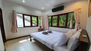 A bedroom with a bed, two windows, a bedside table, and a nightstand. - NB Villa Celina (Koh Samui)