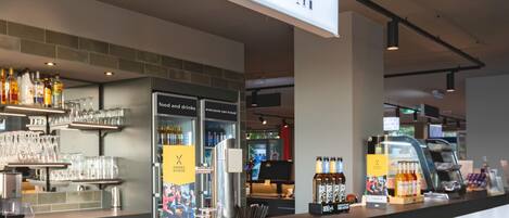 A bar area with a counter displaying various bottles and glasses, a menu board, and a sign indicating the bar section.