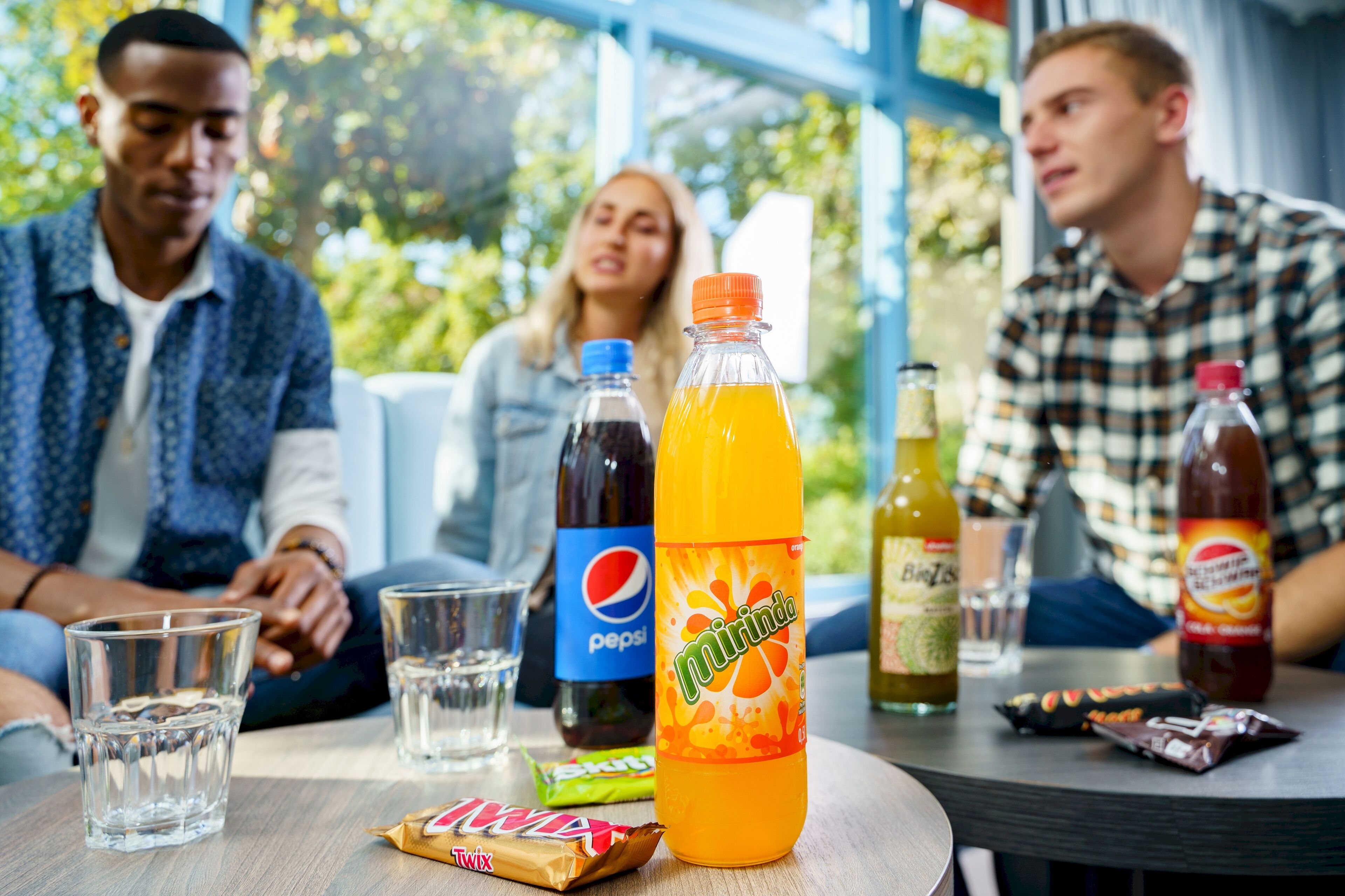 A group of people sitting at a table with beverages and snacks.