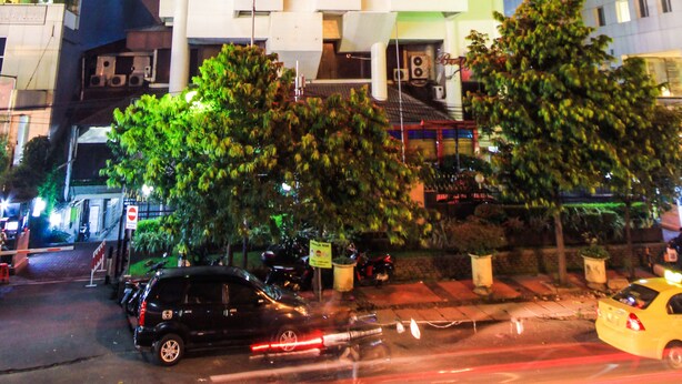 Un edificio a più piani con balconi e un neon.