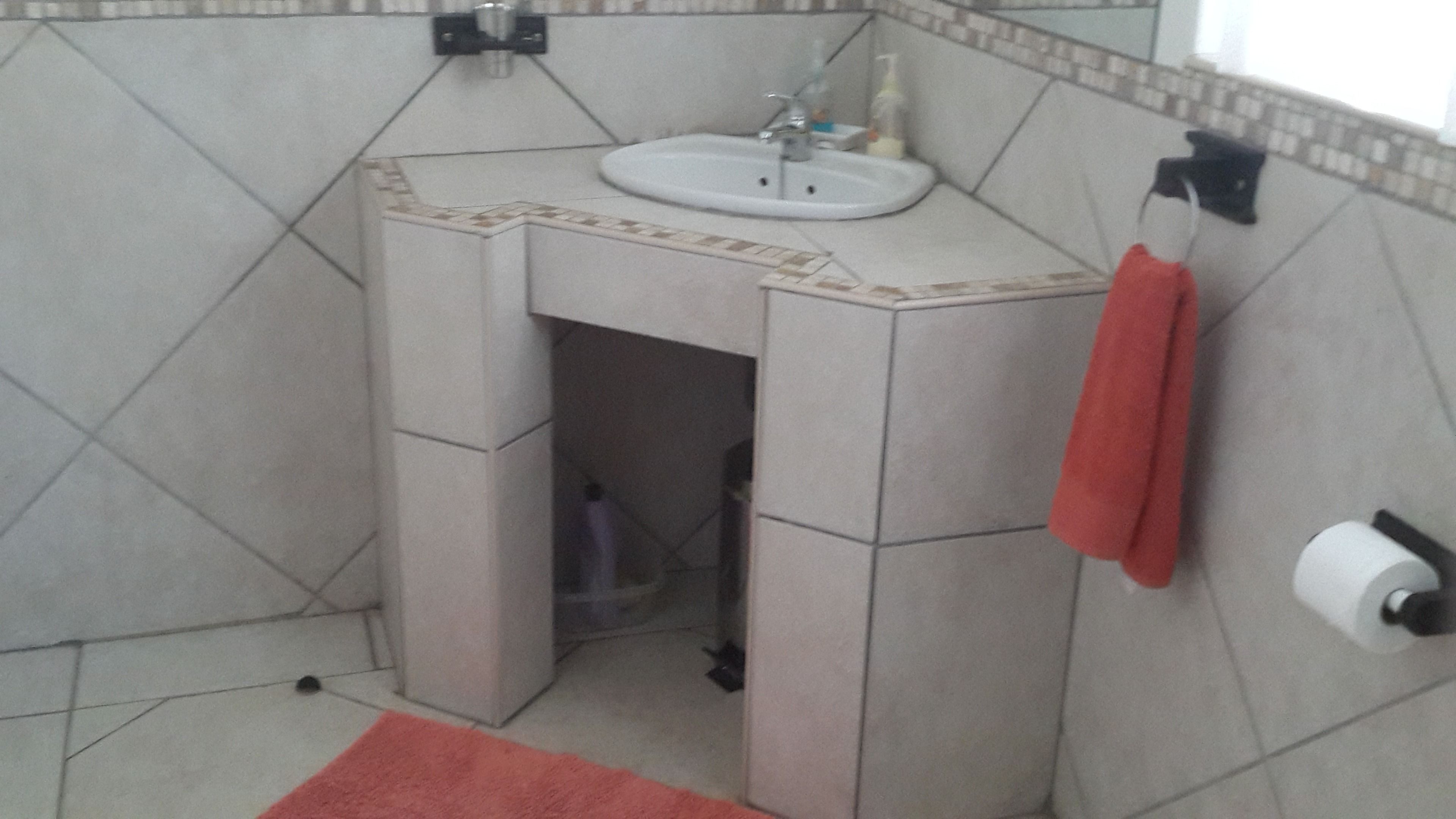 A bathroom with a sink, towel rack, and toilet paper holder.