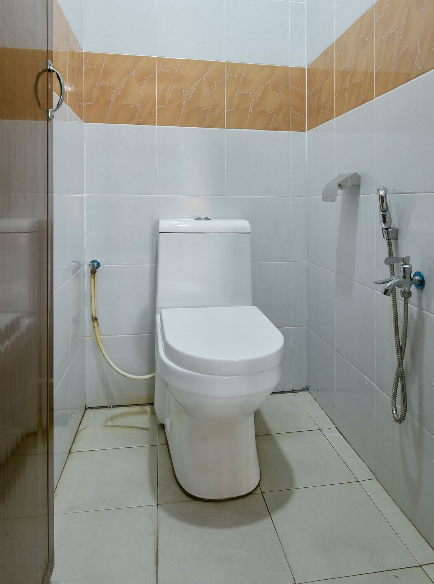 Een badkamer met toilet, douche en een glazen deur.