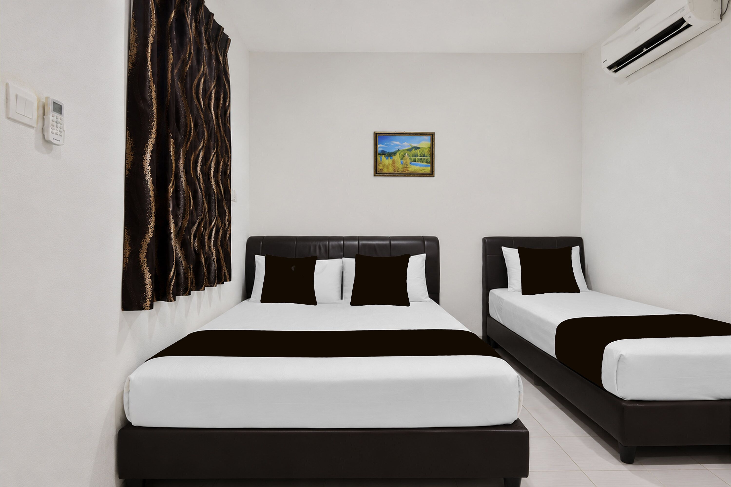 A hotel room with two beds, a painting on the wall, an air conditioning unit, and a control panel.