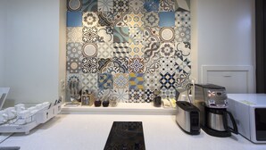 A modern kitchen with a variety of patterned tiles on the backsplash, a coffee maker, a toaster, and a microwave. - K-Guesthouse Myeongdong 1 (Seoul)