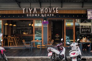 Une devanture de magasin avec une enseigne indiquant : « TIYA HOUSE ROOMS & CAFE ».