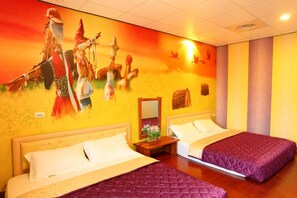 A hotel room with two beds, a large mural on the wall, and a small table with a mirror and flowers. - Family Pottery B&B (Hengchun)