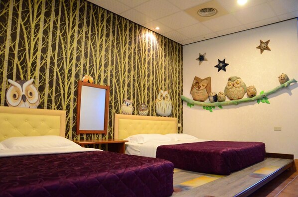 A hotel room with two beds, a large mirror, and wall decorations including owls and stars. - Family Pottery B&B (Hengchun)