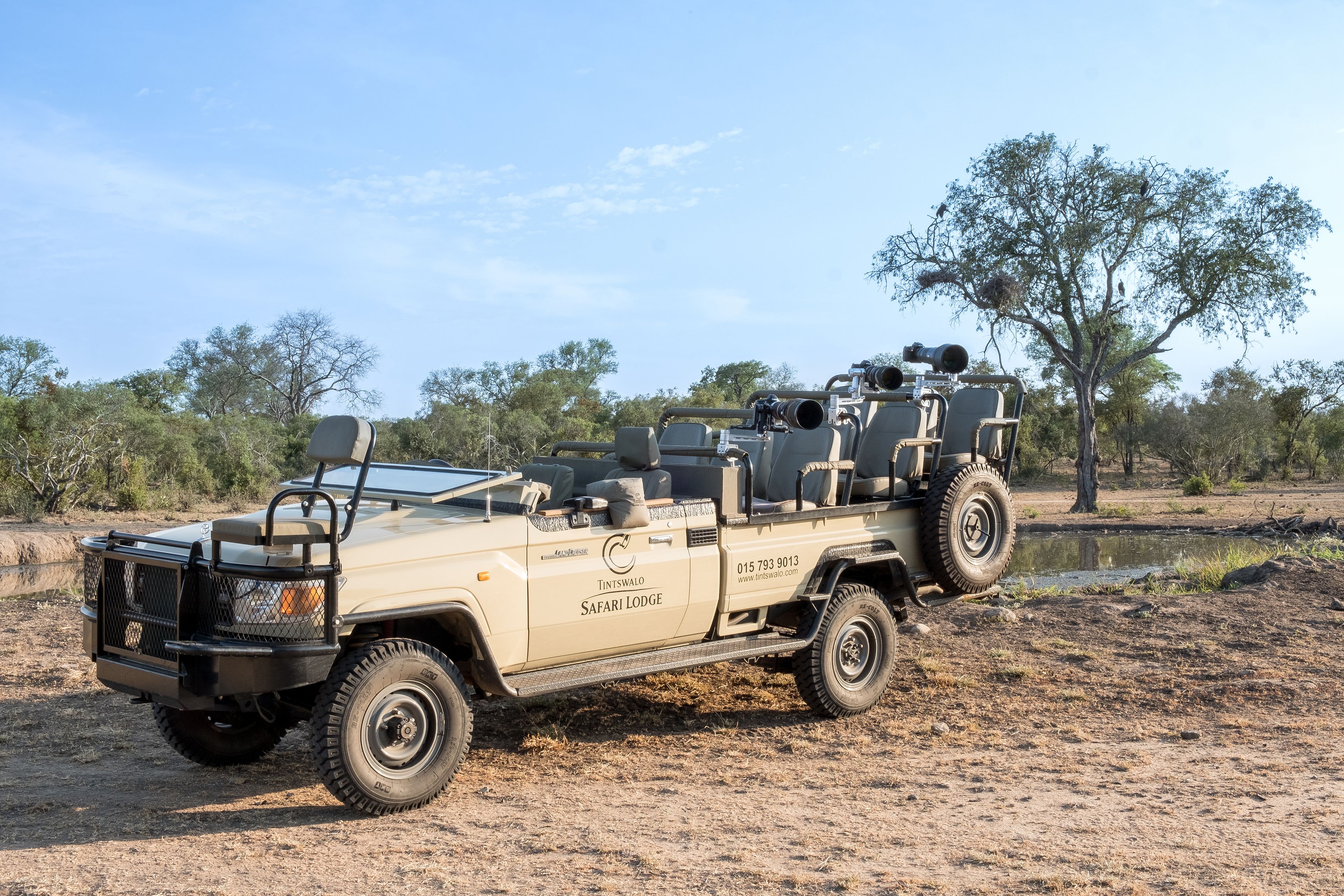 Vehículo tipo lodge de safari con plataforma, equipado con portaequipajes y neumático de repuesto.