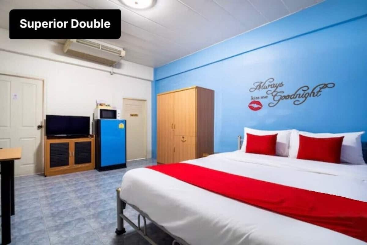 A hotel room with a bed, a television, a wardrobe, and a wall decoration.