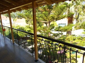A balcony with a view of a garden and a building. - Villa Xenos Studios & Apartments (Zakynthos)