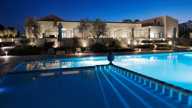 Una piscina con un edificio moderno al fondo.