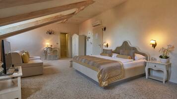 A bedroom with a large bed, a desk, a chair, and a wardrobe.