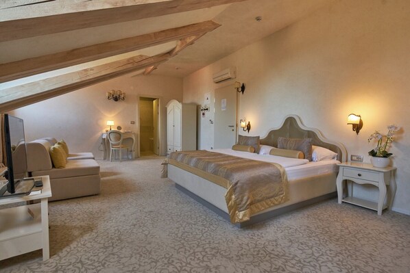 A bedroom with a large bed, a desk, a chair, and a wardrobe.