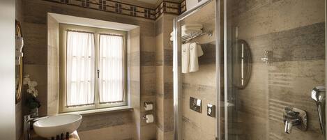A modern bathroom with a large sink, toilet, and walk-in shower.