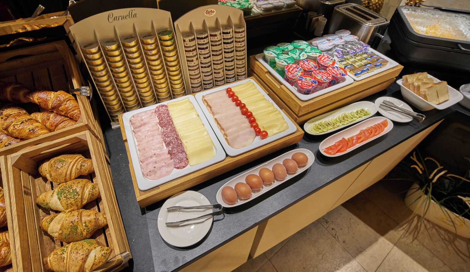 Un bufé con diversos alimentos, incluyendo carnes, quesos y pasteles.