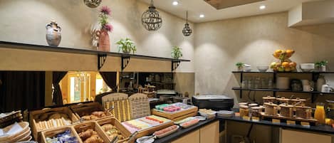 Un buffet de petit-déjeuner proposant une variété d’aliments et un coin café.