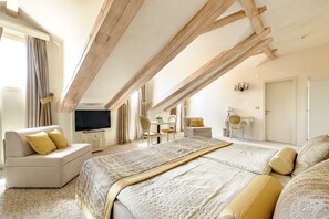 A bedroom with a large bed, a sofa, a TV, and a desk with chairs. - Heritage Hotel Life Palace (Sibenik)