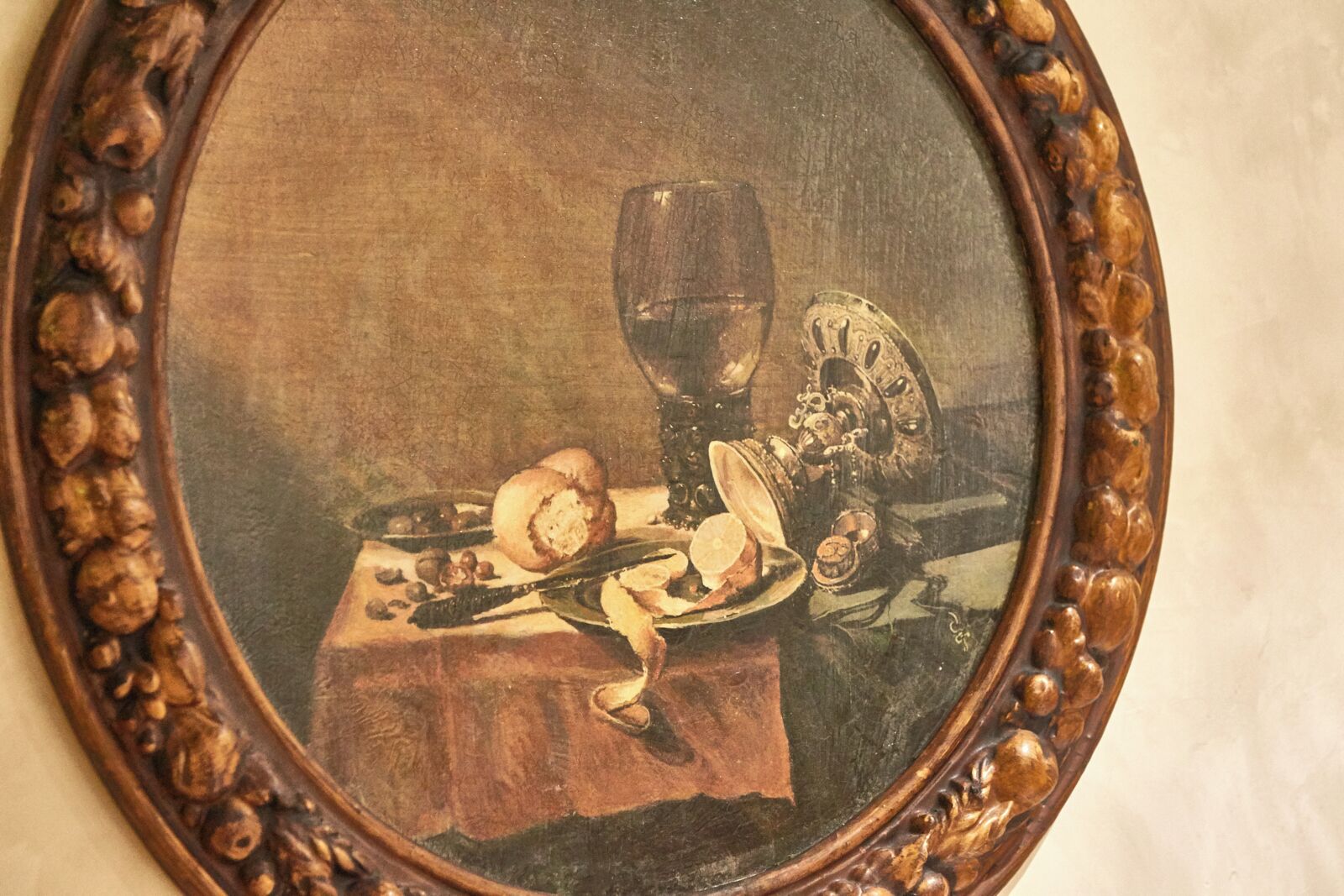 Naturaleza muerta enmarcada con una mesa, una copa de vino y diferentes alimentos.