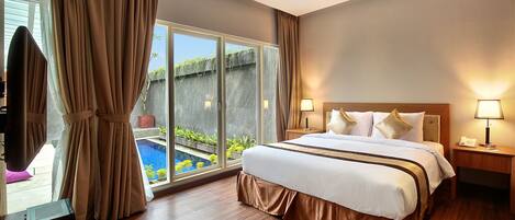 A hotel room with a large bed, two bedside tables with lamps, a TV, and a view of a swimming pool.