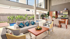 A modern outdoor living area with a pool, seating arrangements, and a kitchen area. - Bellevue Heritage Villas Nusa Dua (Nusa Dua)
