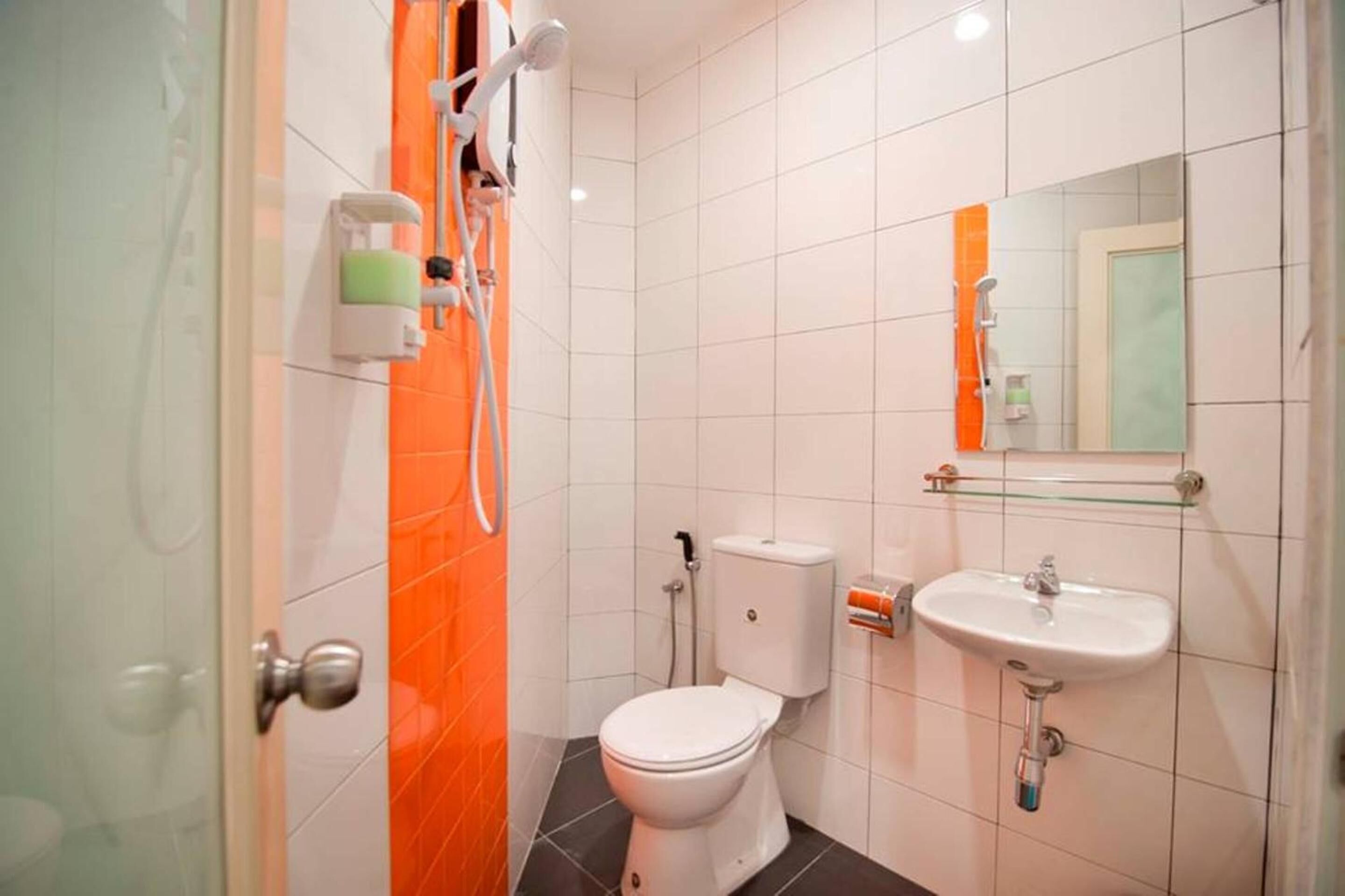 A bathroom with a toilet, sink, and shower.