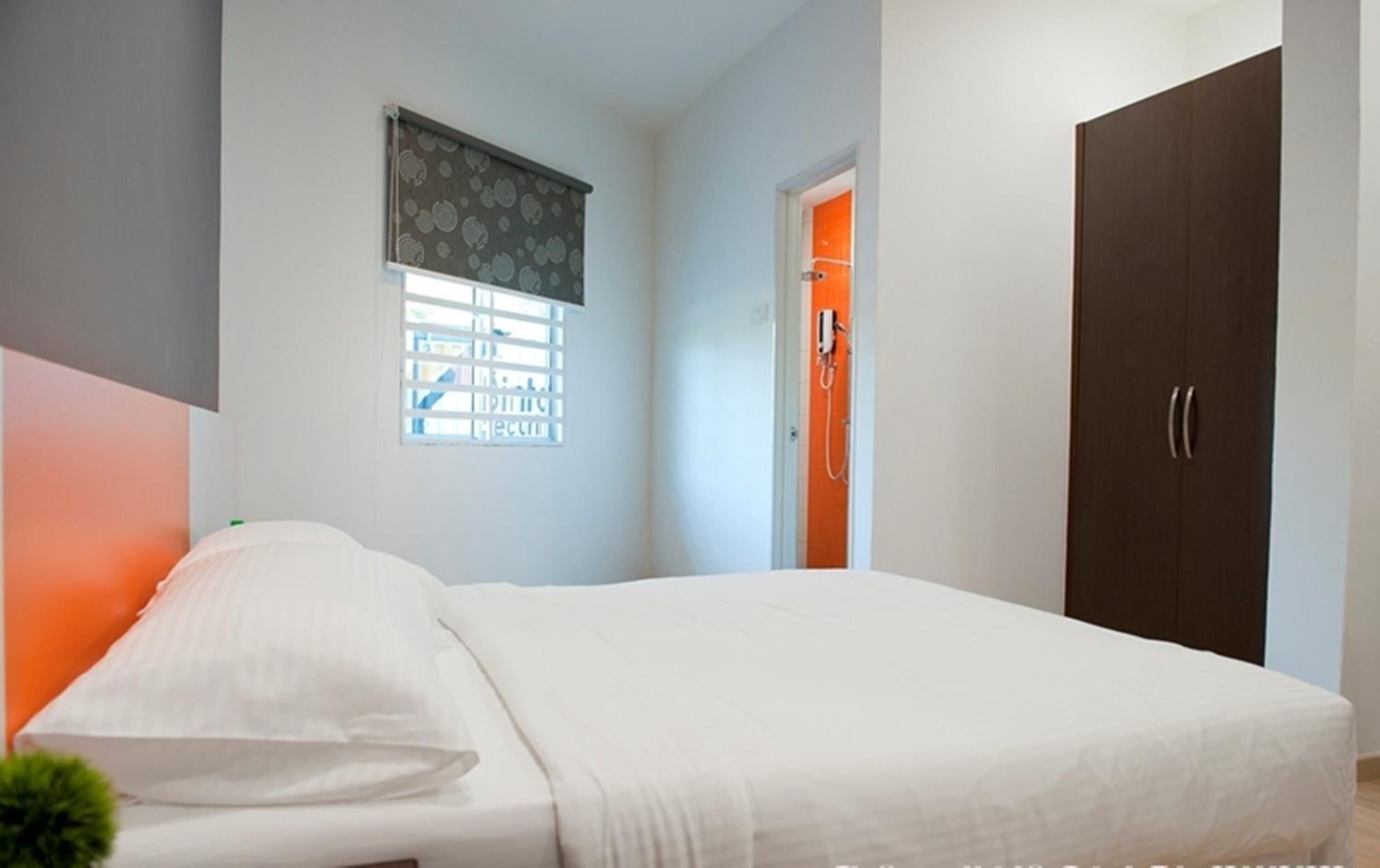 Una camera da letto con un letto, una finestra con persiane, una porta e un armadio.