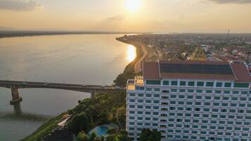 A high-rise building with a swimming pool, a bridge, and a body of water.