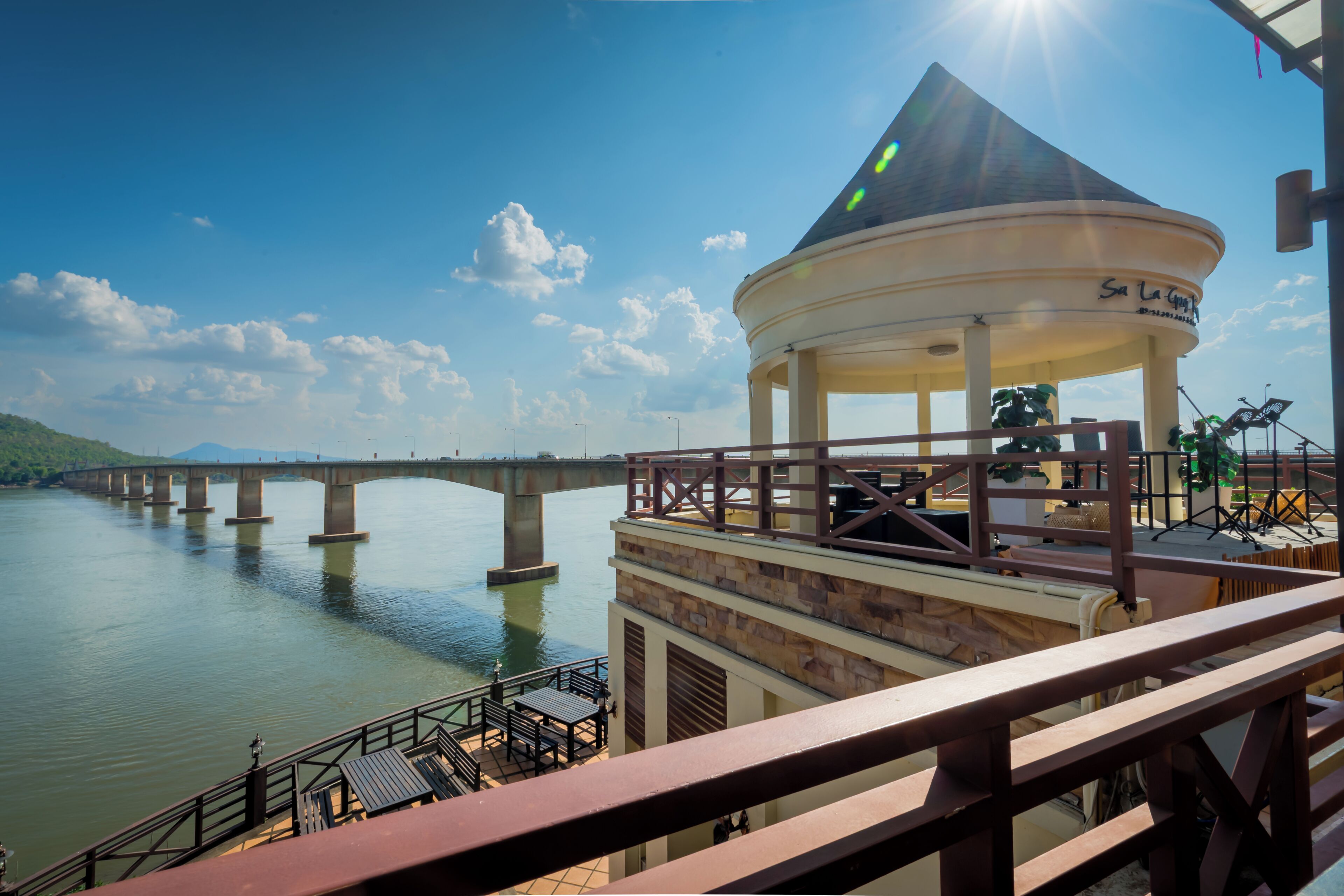 A gazebo with a view of a bridge over water.