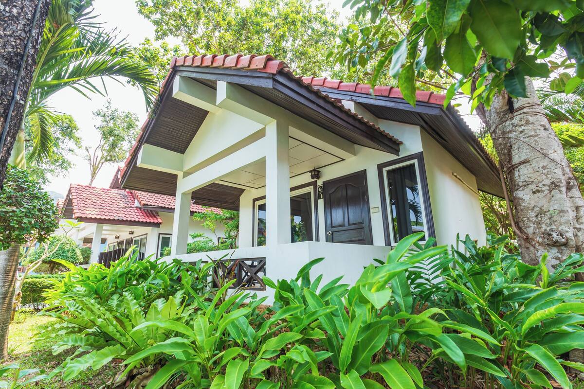 A two-story building with a red-tiled roof and a covered porch.