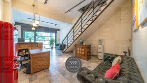 A spacious living area with a staircase, a leather sofa, a wooden desk, and a red cabinet. - Discovery B&B (Hualien City)