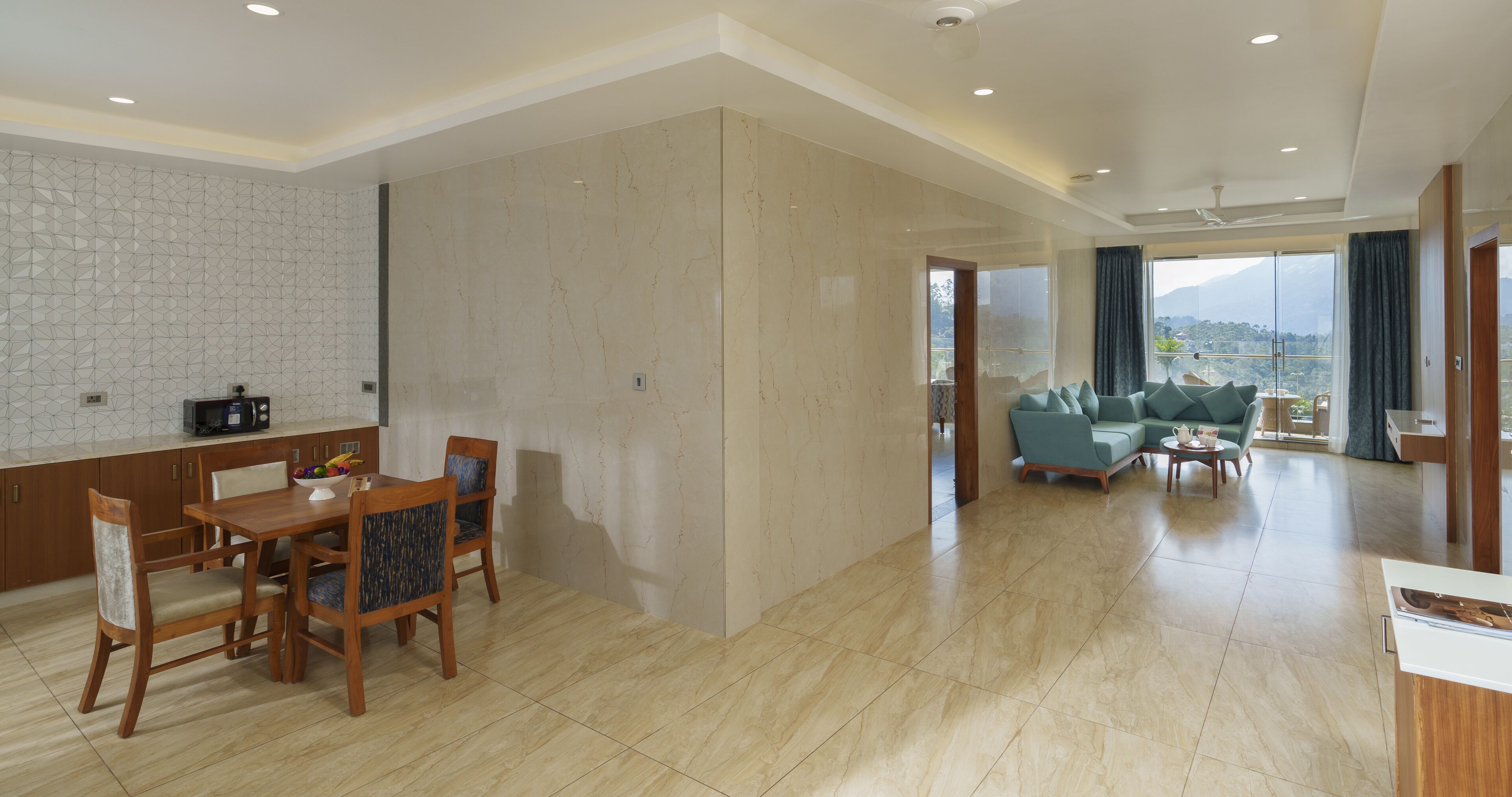 Amplia sala de estar con mesa y sillas de comedor, un conjunto de sofás y vistas al exterior.