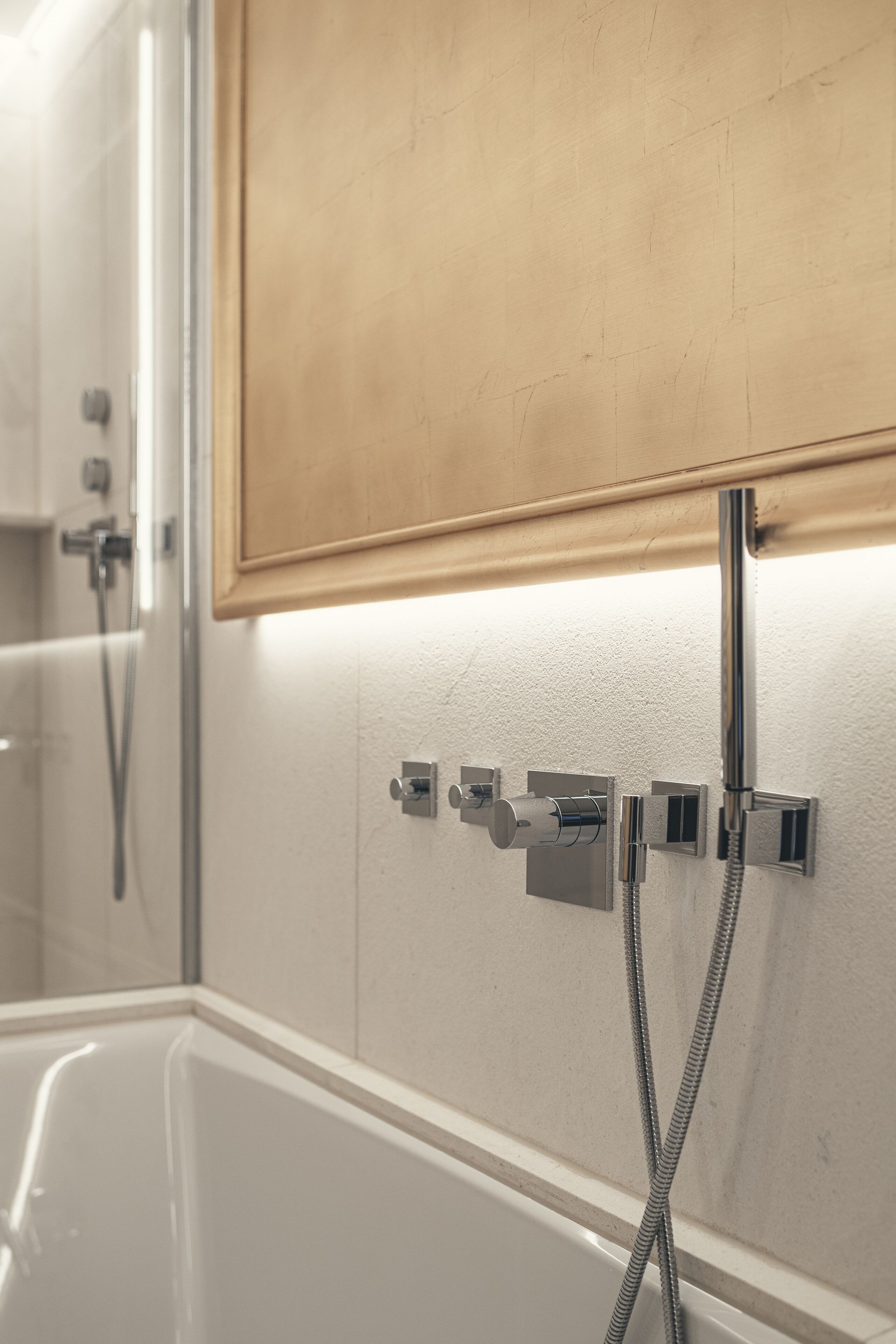 A bathroom with a bathtub, a shower, and a towel rack.
