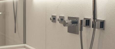 A bathroom with a bathtub, a shower, and a towel rack.