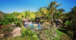 A tropical garden with a swimming pool, palm trees, and a gazebo. - Casas da Vila (Porto Seguro)