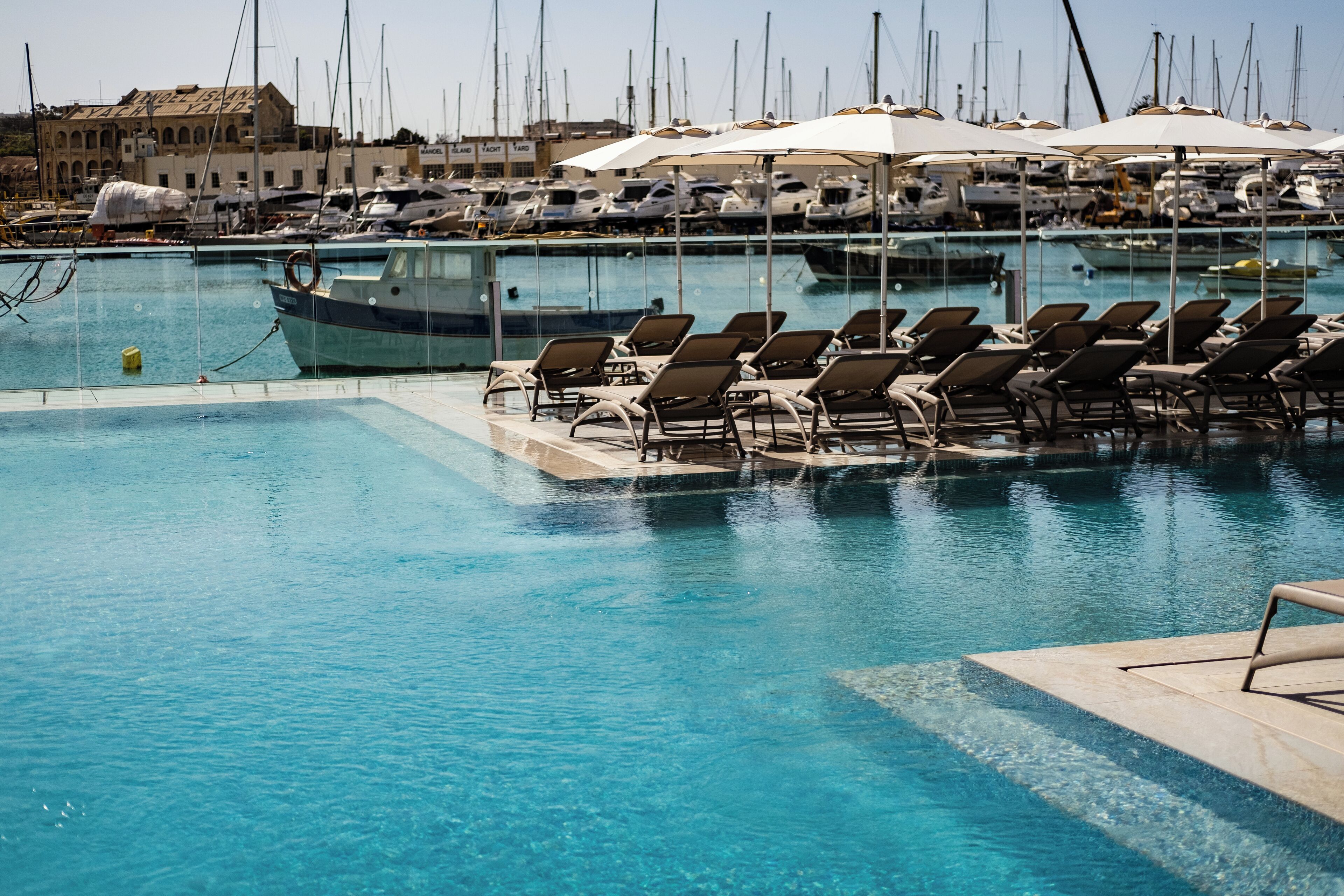 Una piscina al aire libre de temporada, sombrillas