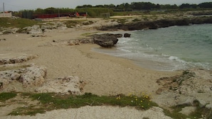 A beach with rocky terrain and a sandy shore. - Masseria Villa Marchesi (Taranto)