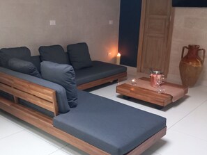 A modern living room with a sofa, a coffee table, and a vase. - Masseria Villa Marchesi (Taranto)