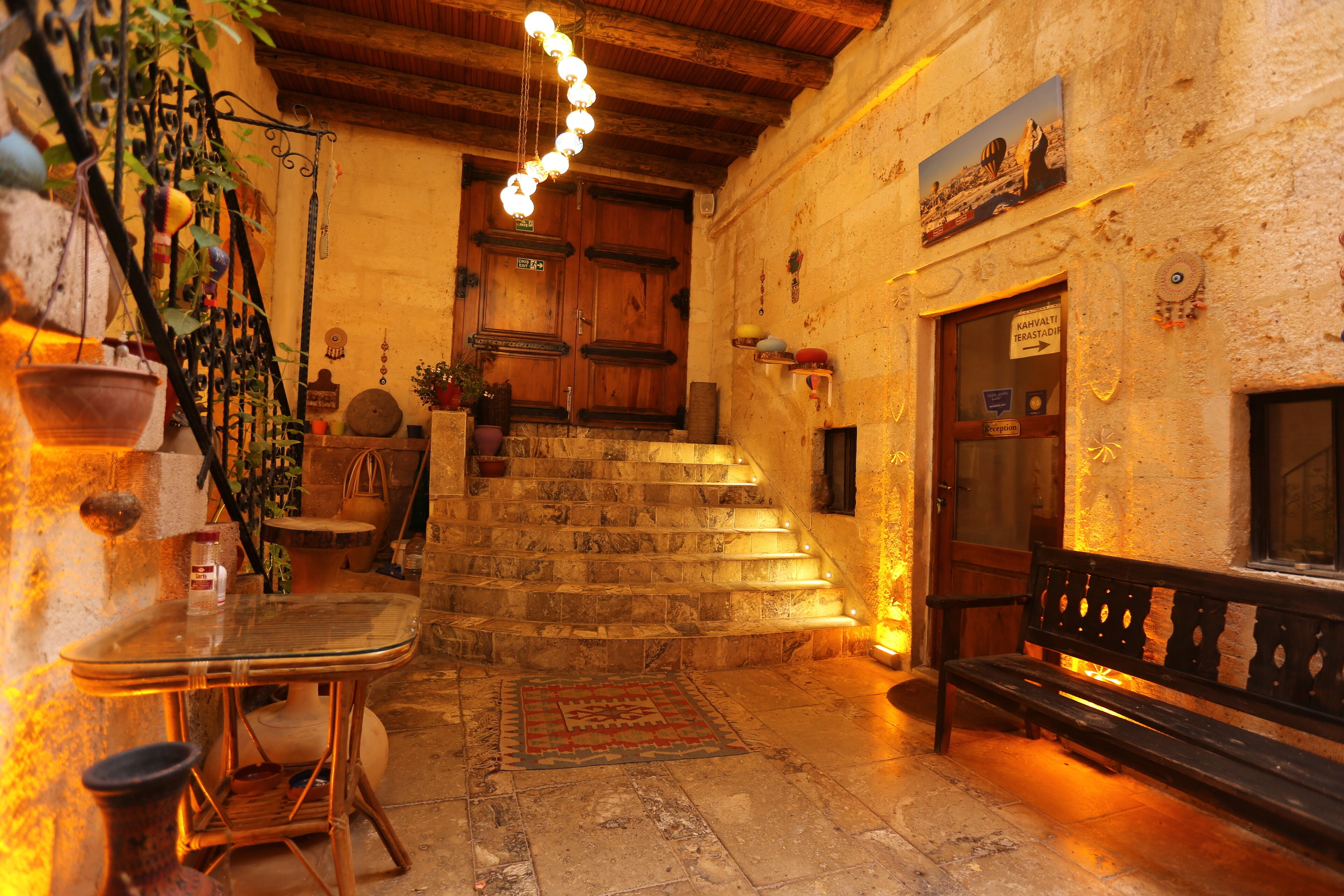 A cozy interior with a staircase leading to a wooden door, a bench, and a table with chairs.
