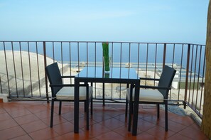 A balcony with a table and chairs, overlooking a beach and the sea. - B&B Il Paradiso di Capri (Anacapri)