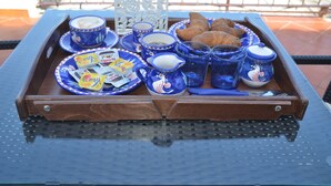 A tray with breakfast items including croissants, coffee, and pastries.