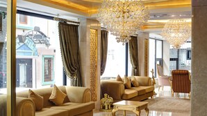 Un salon luxueux avec deux canapés, une table basse et des lustres décoratifs.