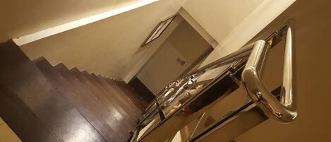 Un escalier avec une rampe et une porte en haut.