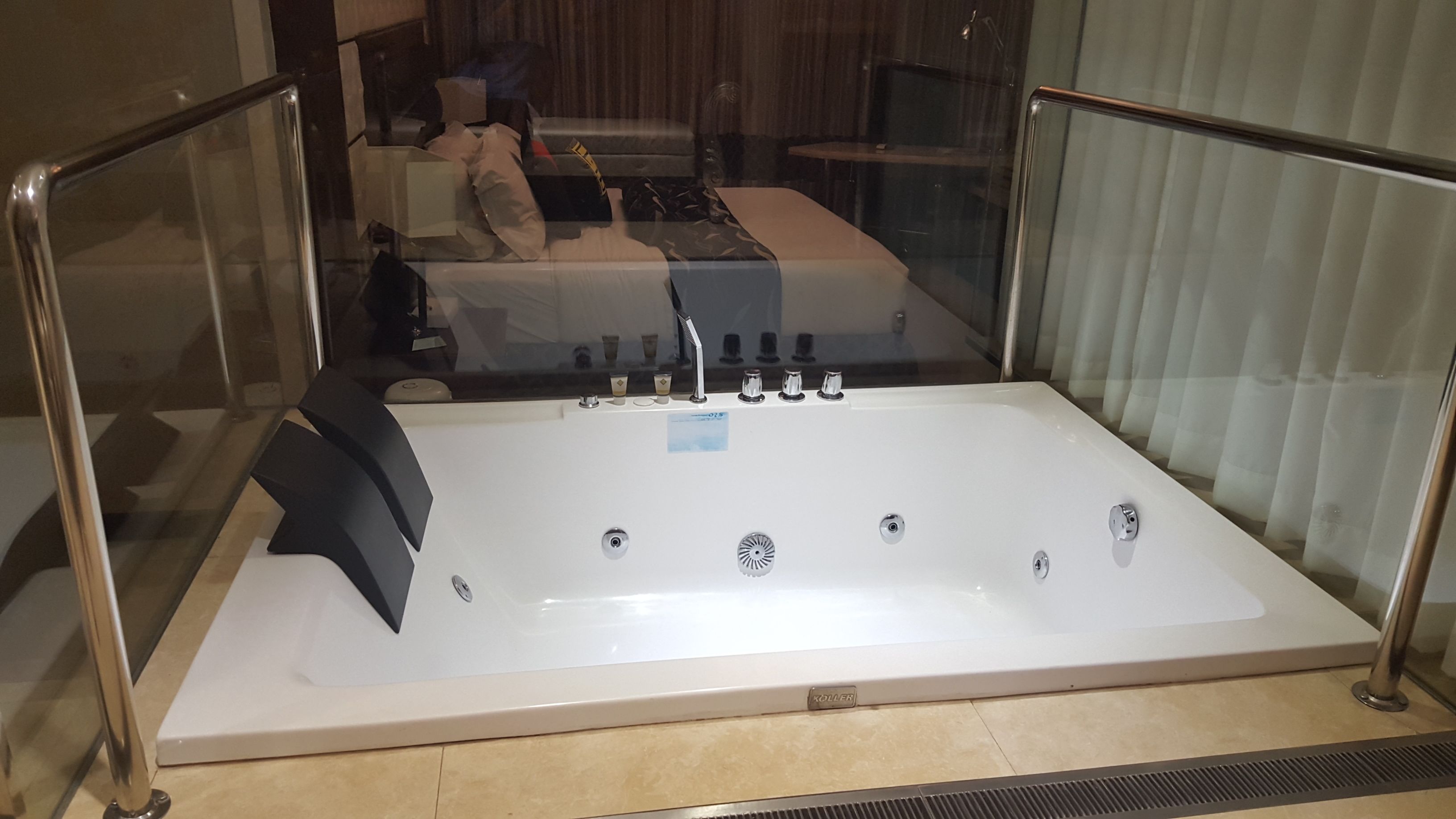 A large, rectangular hot tub with a control panel and a drain.