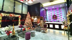 A lobby with a Christmas tree, seating area, and a reception desk. - Prime Asia Hotel (Angeles City)