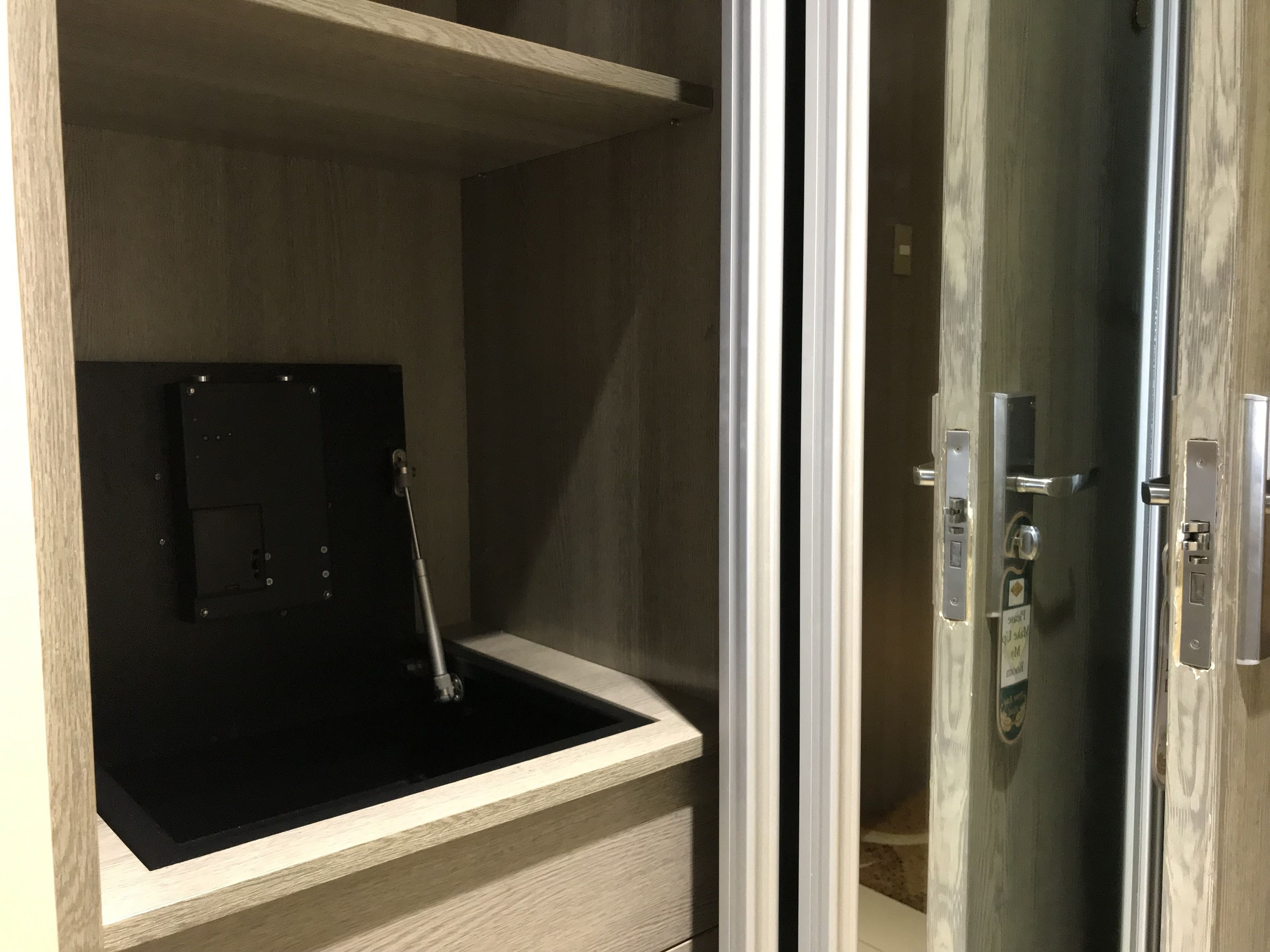 A room with a wooden vanity, a black sink, and a glass door leading to a shower area.