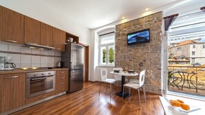 Una cocina moderna con armarios de madera, electrodomésticos de acero inoxidable y una pared de acento de piedra.