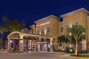 A hotel with a covered entrance, stone pillars, and a sign reading "Best Western PLUS".