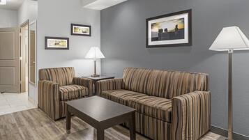 Una sala de estar moderna con un sofá, dos sillones, una mesita de centro y una lámpara de pie.
