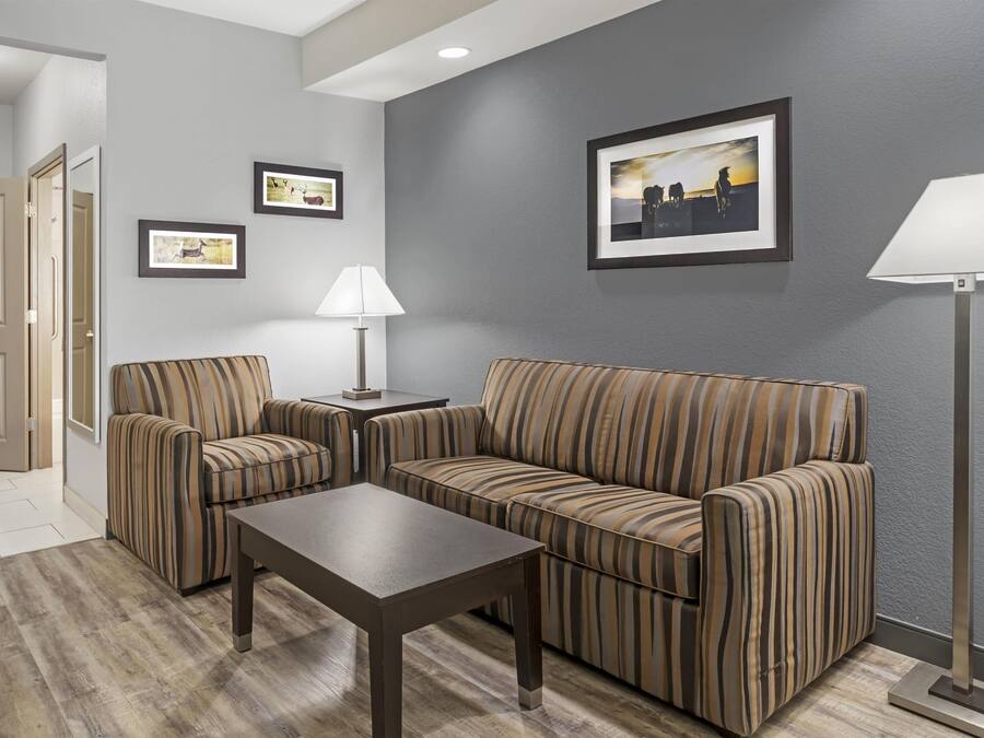 Una sala de estar moderna con un sofá, dos sillones, una mesita de centro y una lámpara de pie.